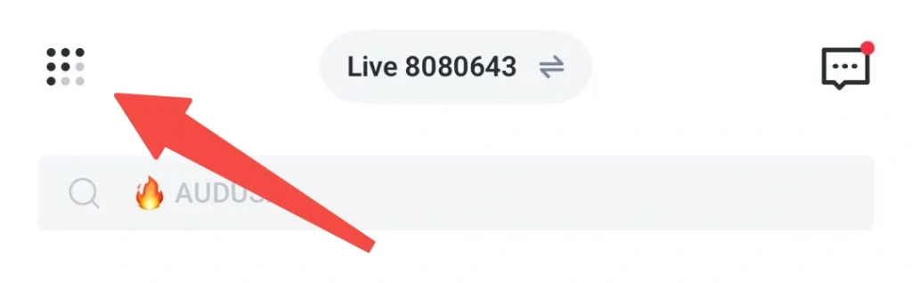 En-tête avec une icône de menu en grille à gauche, un badge « Live 8080643 » au centre et une icône de chat à droite avec un point de notification rouge ; en dessous, une barre de recherche indiquant « 🔥 AUDUS » ; une flèche rouge se superpose à l'icône de gauche.